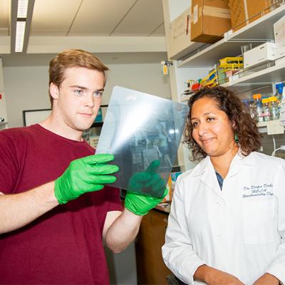 Science faculty working with student.